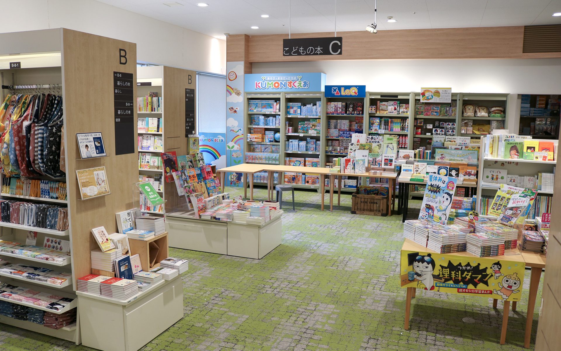 子どもの本・知育玩具コーナー「Do!kids」、カーペット敷きの児童書売場にワークショップ用テーブル